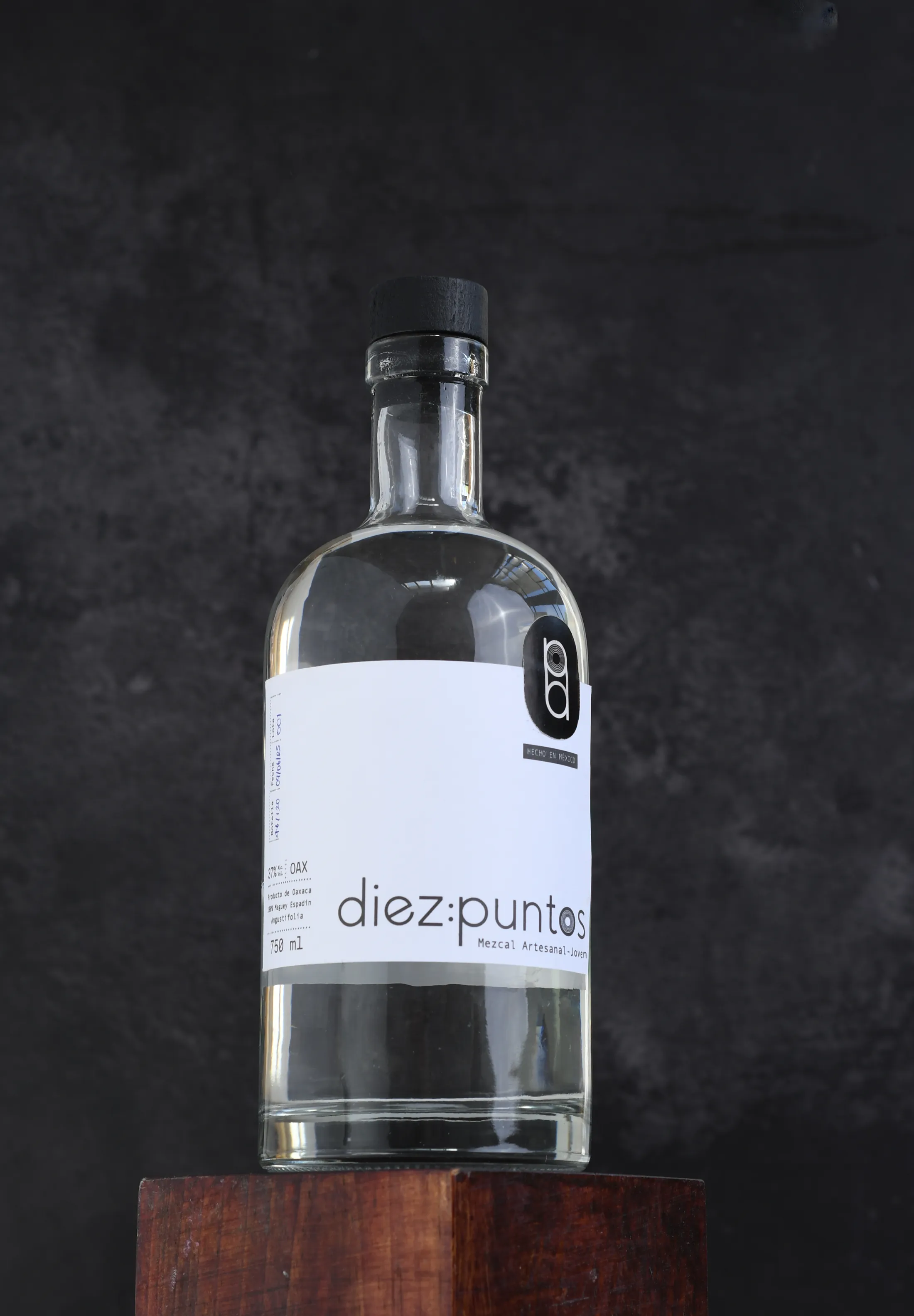 Botella de Diez Puntos, mezcal artesanal Espadín, iluminada sobre un fondo oscuro